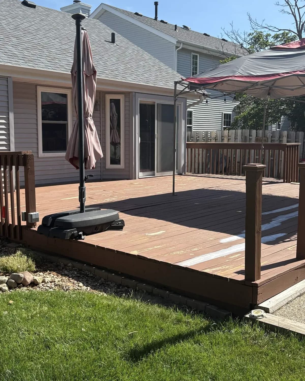 Kim's Loves Park deck before refinishing, with weathered boards and a peeling, sun-faded finish