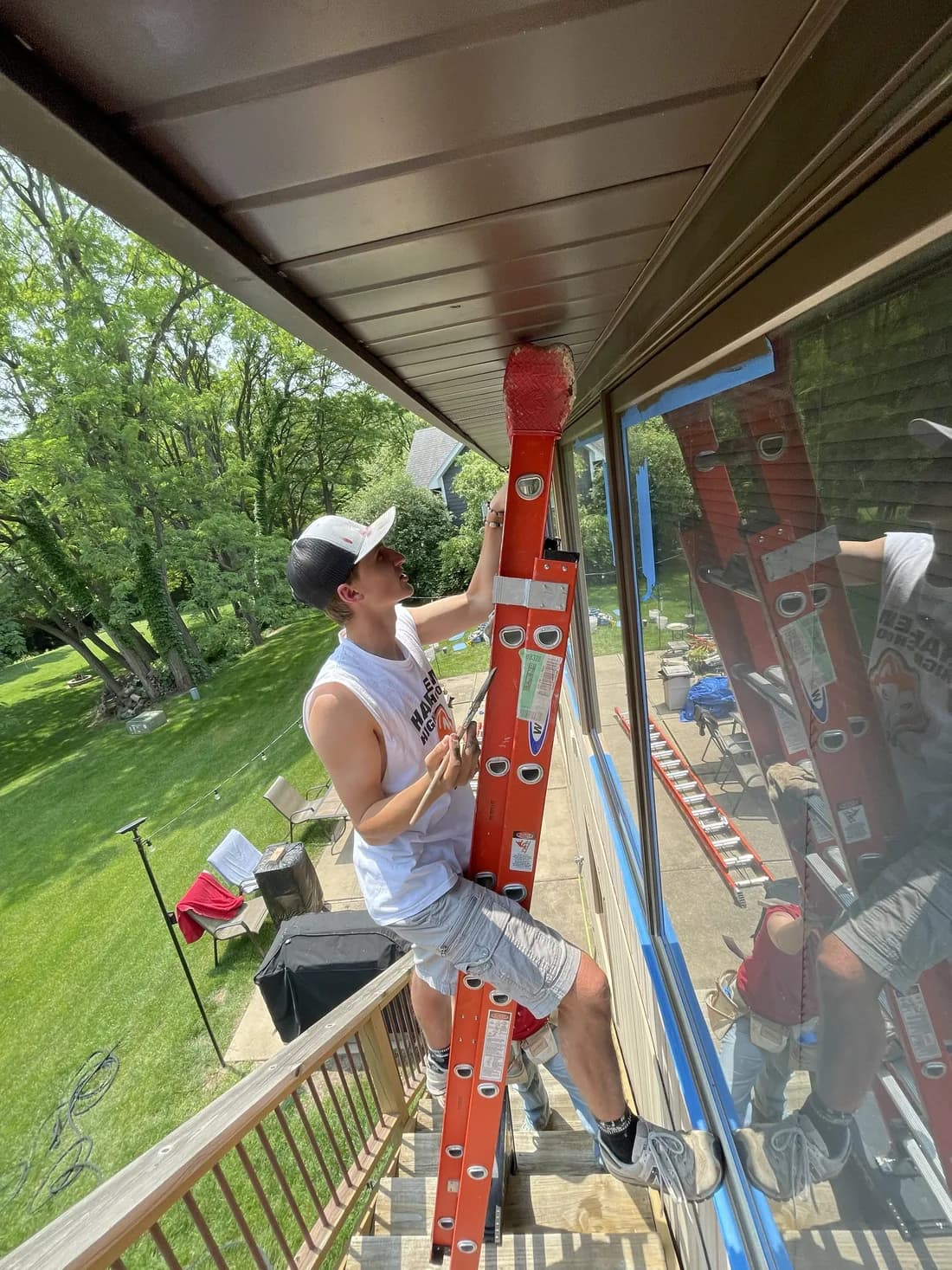 Owner-operator Corbin Kuehne prepping window trim from a ladder