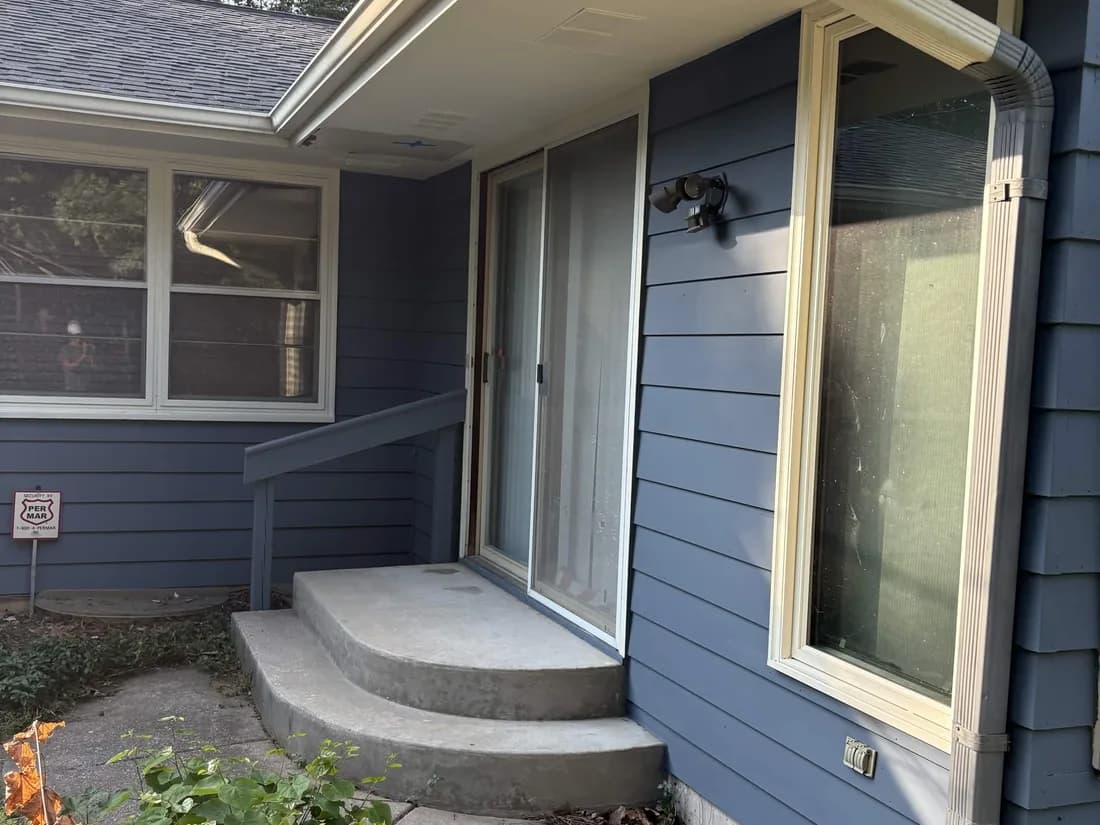 Rear corner of a repainted ranch with clean siding lines and fresh trim